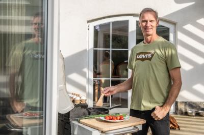 Dominik Hašek stojí u grilu na terase, u grilu jsou vejce a zelenina